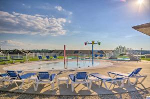 a group of chairs sitting around a pool with a playground at Top-Floor Lands End Corner Unit with Resort Perks! in Osage Beach