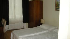 a small bedroom with a bed and a window at Pension Schottentor in Vienna