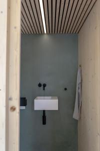 a bathroom with a white sink on the wall at tinyzeit Urlaub im tiny house an der Flensburger Förde in Steinberg