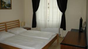 a bedroom with a bed and a window at Pension Schottentor in Vienna
