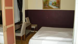a small bedroom with a bed and a chair at Pension Schottentor in Vienna