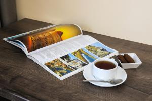 Borys Hotel Boryspil Airport في بوريسبول: طاولة مع كتاب وكوب من القهوة