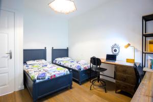 2 Betten in einem Zimmer mit einem Schreibtisch und einem Schreibtisch in der Unterkunft L'OASI DELLA PACE - Confortevole e vicino a tutto in Chiaravalle