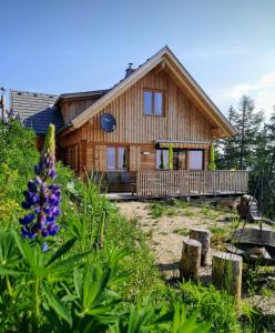 Cabaña de madera con porche y flor en Chalet Die Berghexn en Klippitztorl