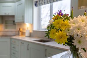 a vase of flowers sitting on a counter in a kitchen at The Grove - Bude Cornwall in Bude