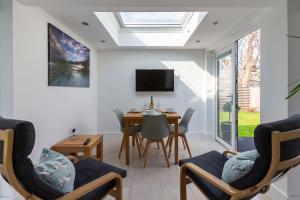 ein Wohnzimmer mit Tisch und Stühlen und einem Fernseher in der Unterkunft The Grove - Bude Cornwall in Bude + 26 Fotos