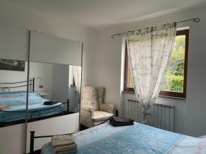 a bedroom with two beds and a mirror and a chair at La casa del Conte - Feriolo di Baveno con giardino privato in Baveno