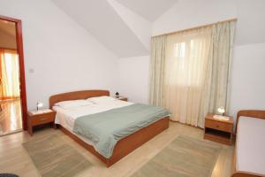 - une chambre avec un lit et une grande fenêtre dans l'établissement Apartments by the sea Postira, Brac - 3244, à Postira