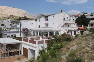 a group of white buildings on a hill at Rooms with a swimming pool Metajna, Pag - 3306 in Zubovići