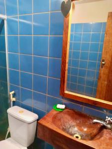 a bathroom with a sink and a toilet and blue tiles at Aconchego da Raquel in Itaúnas +6 photos