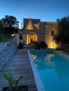 ein Haus mit einem Pool vor einem Haus in der Unterkunft Trullo Nonna Mari in Cisternino