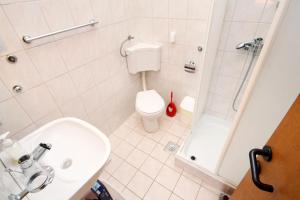a bathroom with a toilet and a sink and a shower at Apartments by the sea Kosljun, Pag - 3321 in Košljun