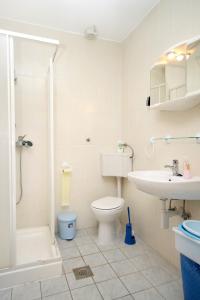 a bathroom with a toilet and a sink and a shower at Apartments by the sea Kosljun, Pag - 3321 in Košljun