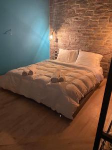 a large bed in a room with a brick wall at Unique space in Gerakas - Cave in Athens