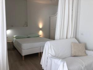 a small bedroom with two beds and a couch at Casa giardino santadi in Santadi