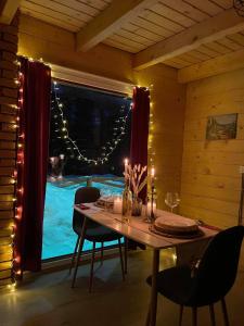 uma sala de jantar com uma mesa e uma janela com luzes em Villat Shkreli Relax em Pec