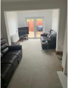 a living room with a couch and a television at 4 Bedroom house with parking, Near Safari Park in Kidderminster