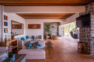 a living room with a couch and a fireplace at Barra do Piuva Porto Hotel in Ilhabela