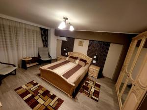 a bedroom with a large bed and a chair at Residence ABBA Maritime in Constanţa