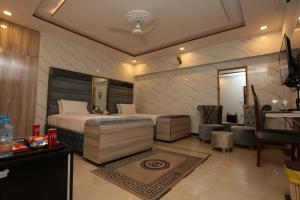 Schlafzimmer mit einem Kingsize-Bett und einem Schreibtisch in der Unterkunft Grand Swiss Hotel&Apartment Lahore in Lahore