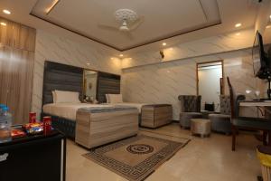 a bedroom with a king sized bed and a desk at Grand Swiss Hotel&Apartment Lahore in Lahore