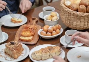 Açores Premium- 5 Minutos do Moinhos de Vento في بورتو أليغري: طاولة مع أطباق من المعجنات وأكواب القهوة