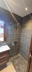 een badkamer met een douche en een wastafel bij Al Anouar Résidence in Kenitra