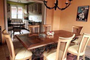 una cucina e una sala da pranzo con tavolo e sedie in legno di House MayFa 