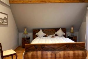 a bedroom with a large bed with a wooden headboard at House MayFa in Riedseltz