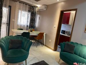 a living room with green chairs and a table at At Home Lisda in Yaoundé