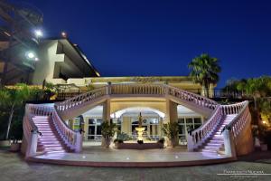 un grand bâtiment blanc avec un escalier en avant dans l'établissement Grand Hotel Stella Maris Italia, à Palmi