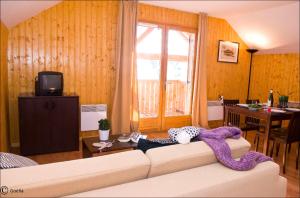 a living room with a couch with a blanket on it at Résidence Goélia Les Chalets des Ecourts in Saint-Jean-dʼArves