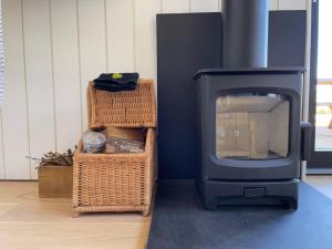 a living room with a wood stove and baskets at The Kuhvee in Exeter