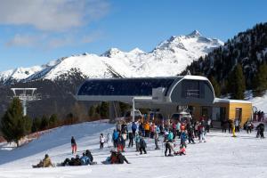 eine Gruppe von Menschen, die im Schnee in der Nähe eines Skilifts sitzen in der Unterkunft Residence Pfeifhofer in Sand in Taufers