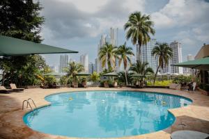 a large swimming pool with a city skyline in the background at Plaza Paitilla Inn in Panama City