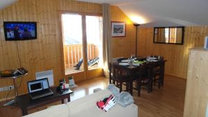 a living room with a table and a couch and a dining room at Résidence Goélia Les Chalets des Ecourts in Saint-Jean-dʼArves