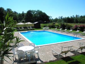 a pool with chairs and a table and a table and chairs at Agriturismo Buonasera in Bagnoregio