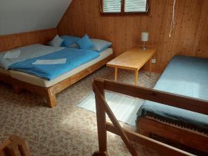a bedroom with two twin beds and a table at ZÁTOKA Živohošť - Apartmány in Chotilsko