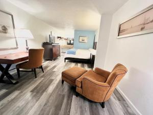 a living room with a chair and a desk and a bed at Bayou Inn & Suites in Bayou La Batre