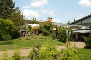 un bâtiment avec un jardin en face dans l'établissement Landhotel Sonnenbühl, à Sonnenbühl