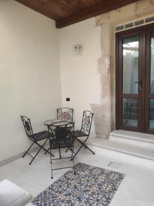 a patio with a table and chairs and a window at Al Settimo porta marina in Syracuse