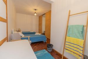 a woman sitting in a room with a bed and a mirror at Casa da Margarida in Ponta Delgada