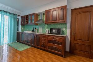 a kitchen with wooden cabinets and a microwave at Casa da Margarida in Ponta Delgada
