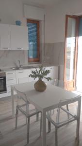 un tavolo bianco con un vaso sopra in cucina di Casa Francesca a Torre Canne