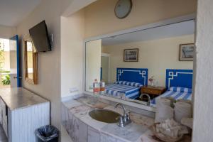 a bathroom with a sink and a large mirror at Acamar Beach Resort in Acapulco