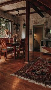 een woonkamer met een tafel en stoelen en een tapijt bij Rent a Forest, Cabin Hidden in the Fruška gora in Velika Remeta