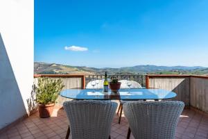 Montefino的住宿－Villa Ferranti Abruzzo，阳台上的桌椅和一瓶葡萄酒