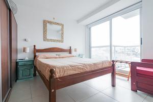 a bedroom with a bed and a large window at Los Asturianos APART amentos in Mar del Plata