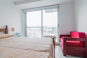 ein Schlafzimmer mit einem Bett und einem großen Fenster in der Unterkunft Los Asturianos APART amentos in Mar del Plata