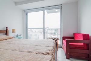 a bedroom with a bed and a large window at Los Asturianos APART amentos in Mar del Plata